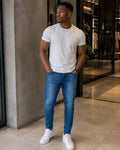 Model wearing Auren Milano blue distressed slim jeans